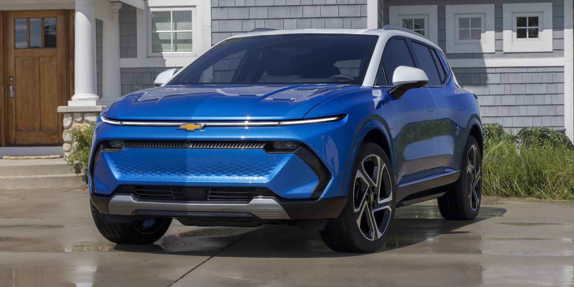 2025 Chevrolet Equinox EV 3LT Front 7/8 view of 2025 Chevrolet Equinox EV 3LT in Riptide Blue parked in front of a home. Preproduction model shown. Actual production model may vary. (image courtesy GM)