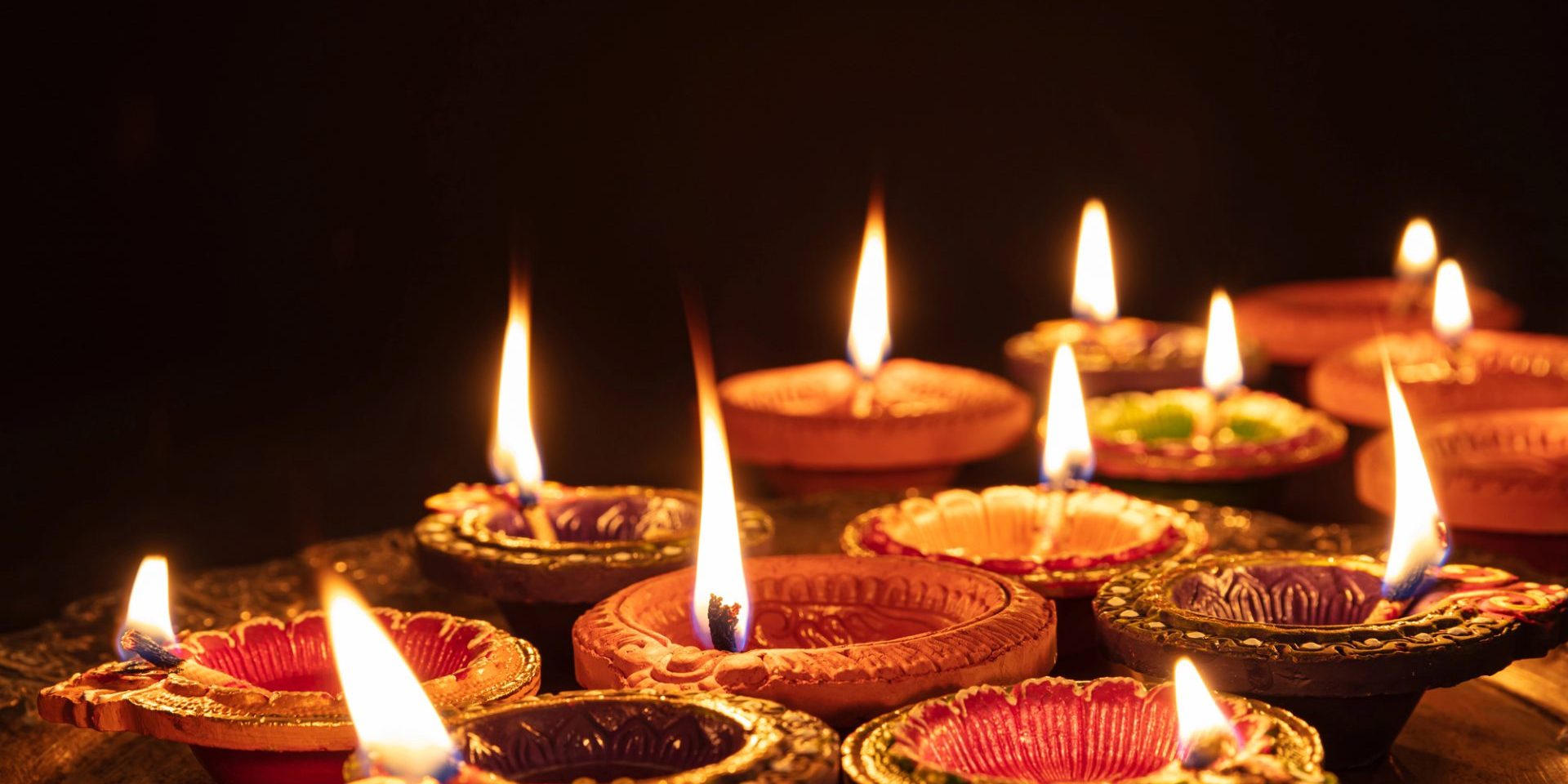 Diwali, Hindu festival of lights celebration. Diya oil lamps against dark background (image courtesy Deposit Photos)