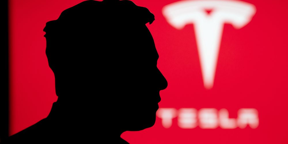 Silhouette of Elon Musk portrait, billboard of Tesla on red background — Photo by kovop58@gmail.com Silhouette of Elon Musk portrait, billboard of Tesla on red background — Photo by kovop58@gmail.com
