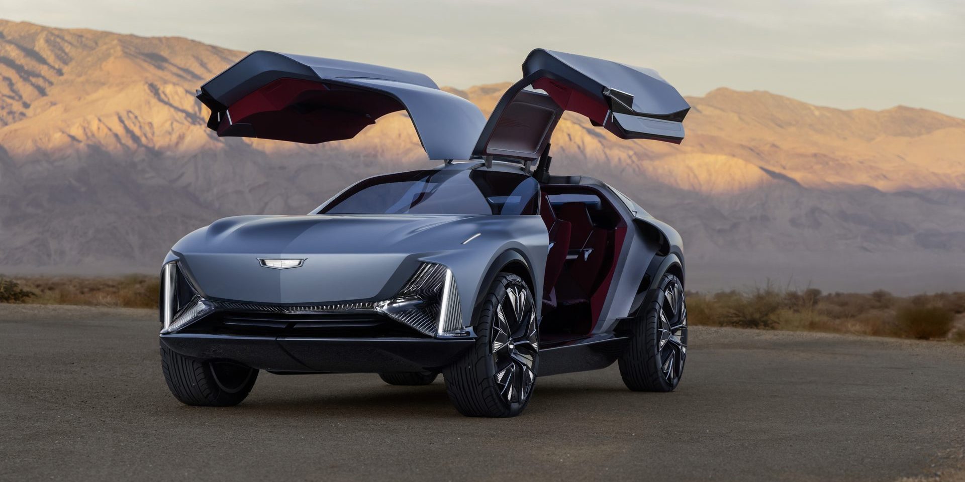 Front 3/4 view of the Cadillac Elevated Velocity concept in Vapor Blue with the gull-wing doors open with the desert in the background.