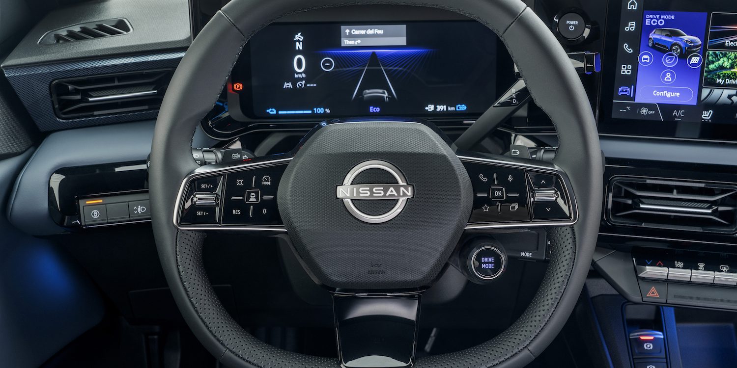 steering wheel detail showing Nissan logo, combimeter and dials
