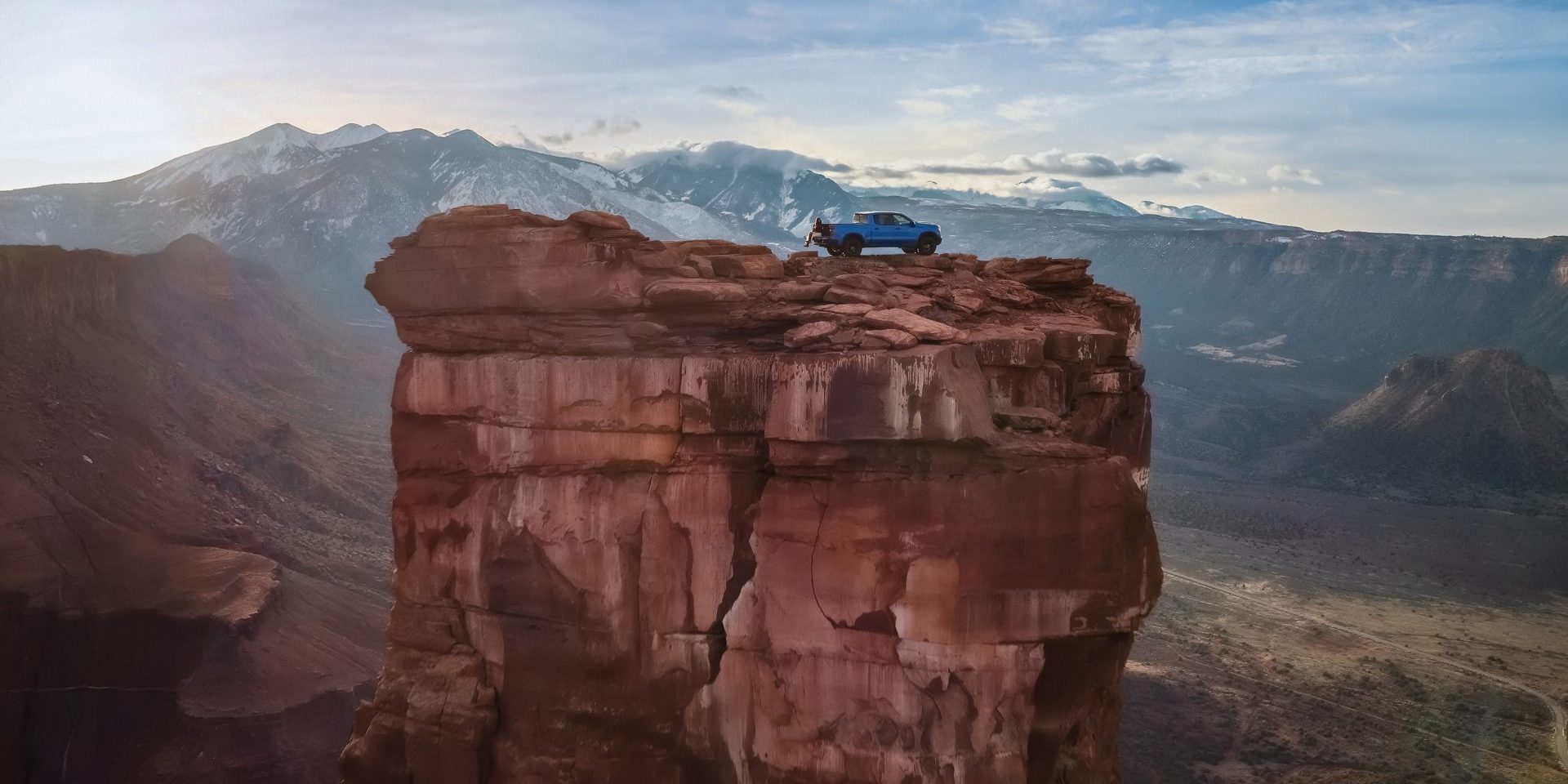 Wide shot of the Silverado ZR2 and Brooke Lee on top of Castleton Tower in Utah.
